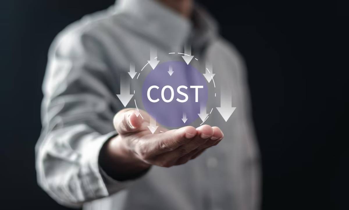 A person in a gray shirt holds out a hand displaying a circular graphic of the word COST with downward arrows, symbolizing cost management.