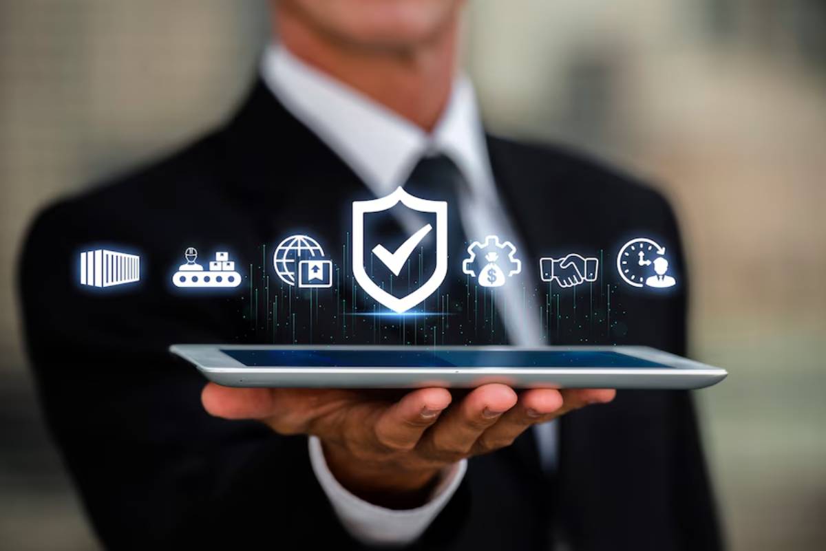 A businessman in a suit holds a tablet displaying digital icons representing security, logistics, and global connectivity.
