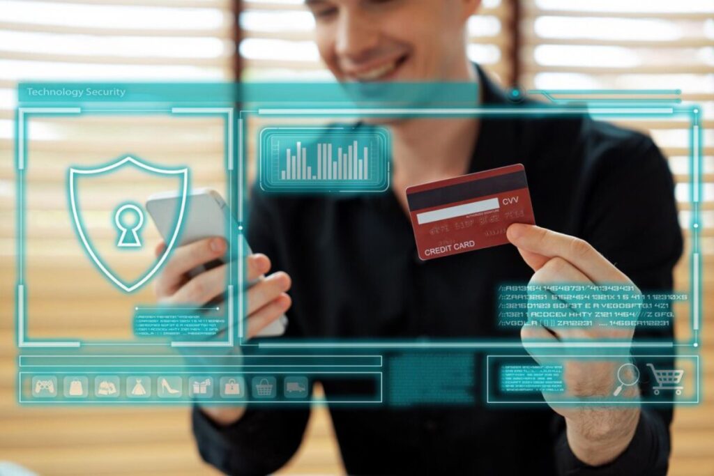 A person holds a smartphone in one hand and a credit card in the other, surrounded by digital security graphics.
