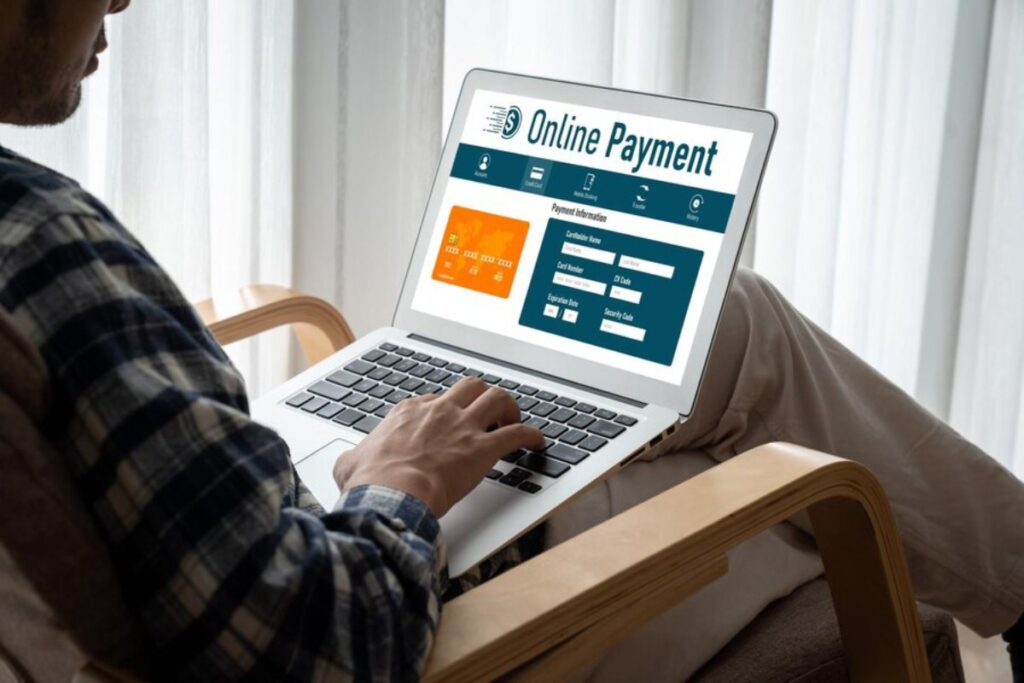 A person using a laptop to make an online payment, entering credit card details on a website with a clean, modern interface.