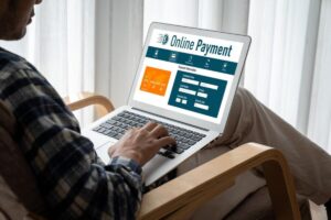 A person using a laptop to make an online payment, entering credit card details on a website with a clean, modern interface.