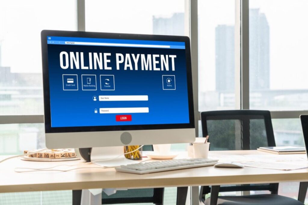 A computer screen displays an Online Payment login page with options for credit card, mobile banking, and transfers. A workspace is visible.