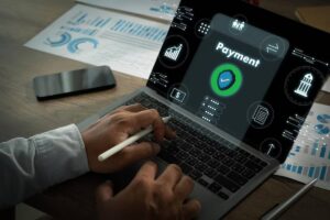 A person using a laptop with a focus on a Payment feature, surrounded by financial icons and data analytics graphics.
