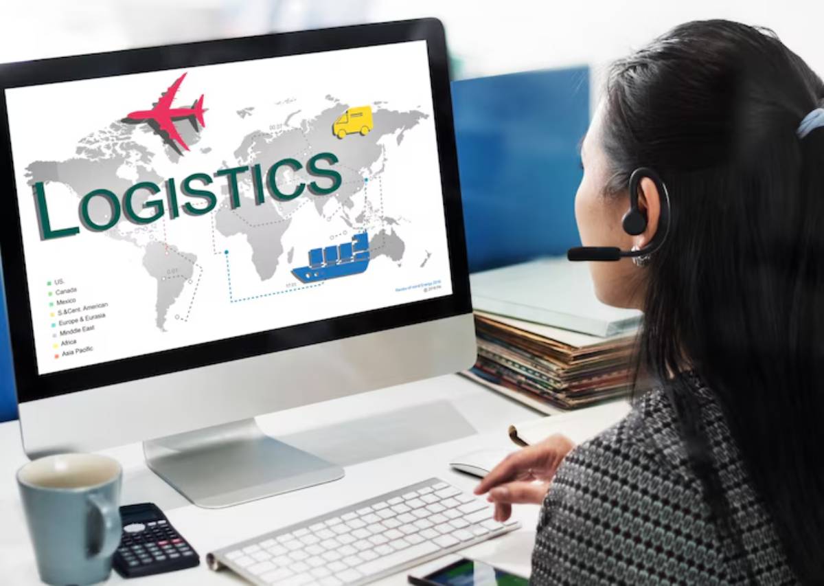 A woman in a headset looks at a computer screen displaying a world map with icons for logistics, including aircraft and cargo ships.