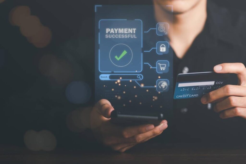 A person holding a smartphone displays a Payment Successful notification, while also holding a credit card in the other hand.